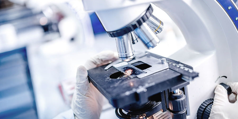 Details of medical laboratory, scientist hands using microscope
